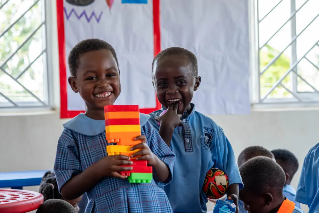 Zwei lachende Kinder im Kindergarten von PMCO in Uganda